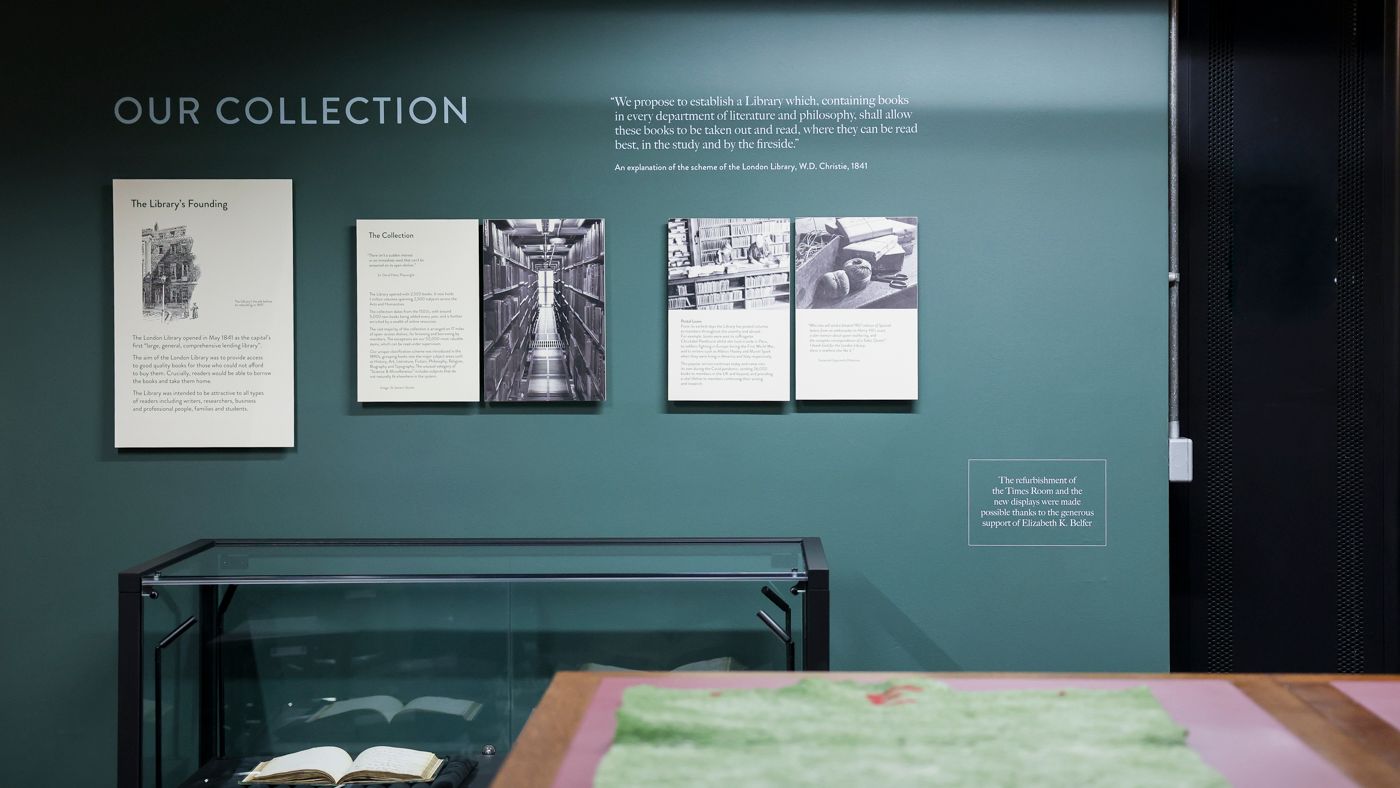 An exhibition wall headed "Our Collection", with display panels and an open book in a glass case.