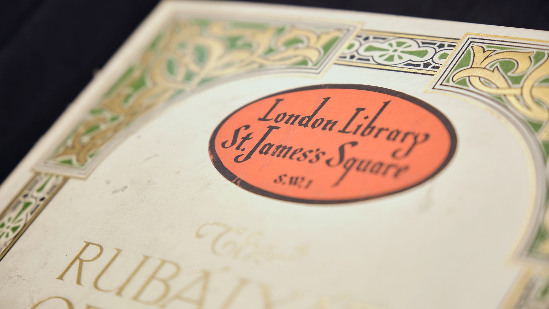 A red oval London Library bookplate on the decorated endpaper of an illuminated binding.
