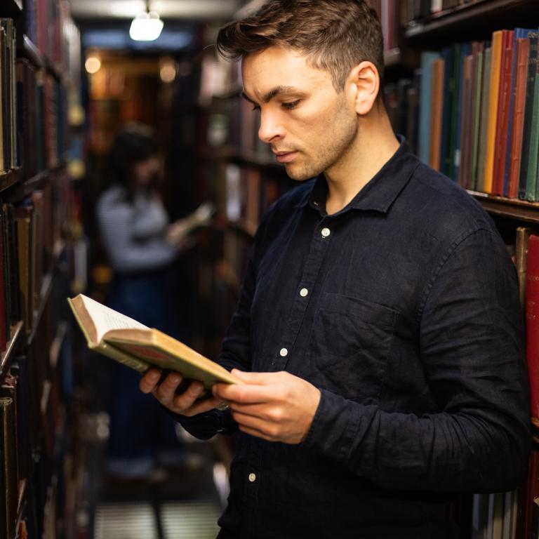 Man reading in stacks of the library
