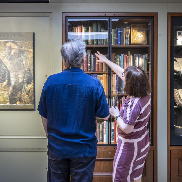 Man and woman looking at a display case of books 