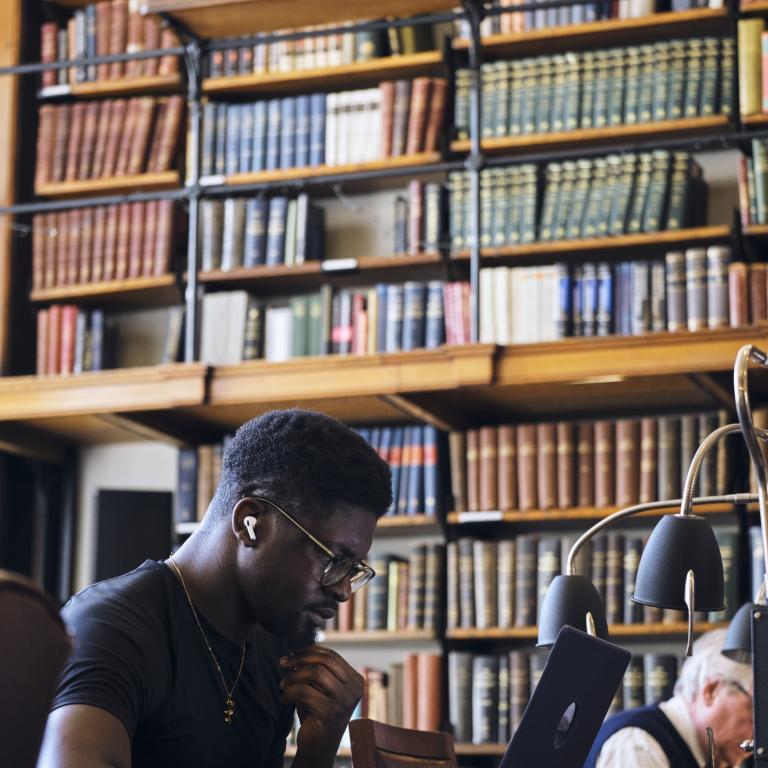 Man studying on laptop in the Reading Room at The London Library