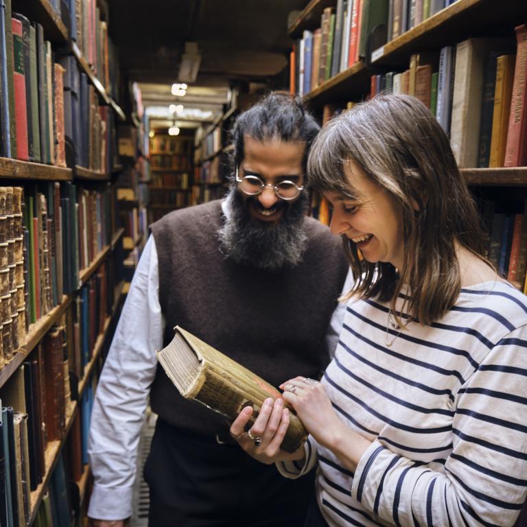 Man and woman smiling at a book in the woman's hands