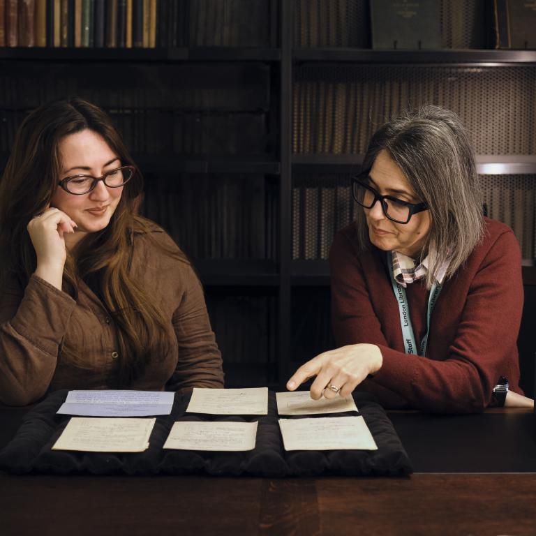 Two women reading archive materials