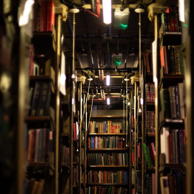 A stairway between tightly packed shelves in the book stacks.
