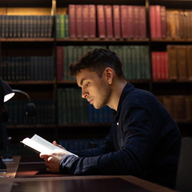 Man reading a book in the library