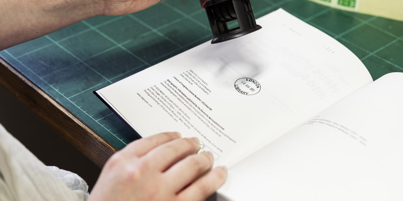 Hands stamping a library book