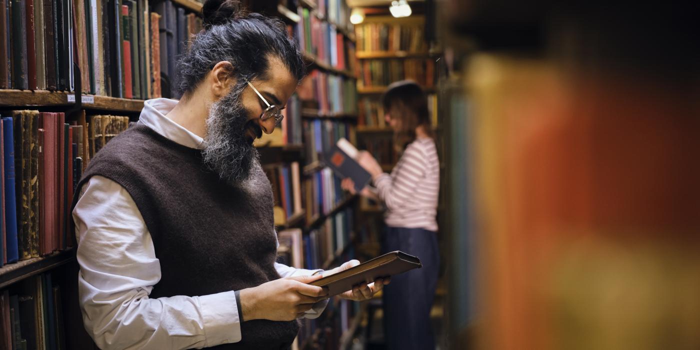Man reading a London Library book in the backstacks at The London Library