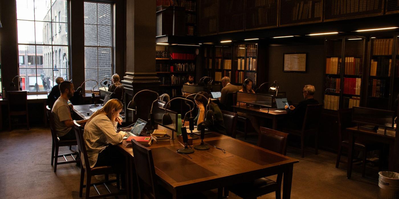 Members working at reading desks in a tall galleried reading room.