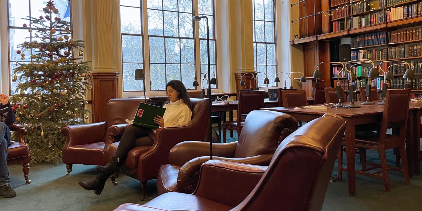 Lady sitting on a chair reading in the library