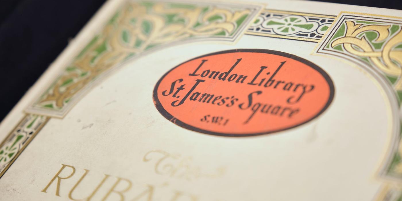 A red oval London Library bookplate on the decorated endpaper of an illuminated binding.