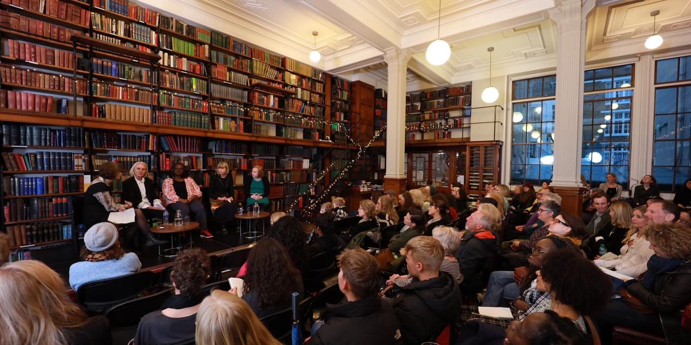 A panel discussion at Lit Fest 2023 before a full audience in the book-lined hall.