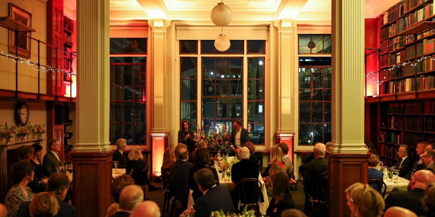 Event with people sitting at round tables looking at those speaking 