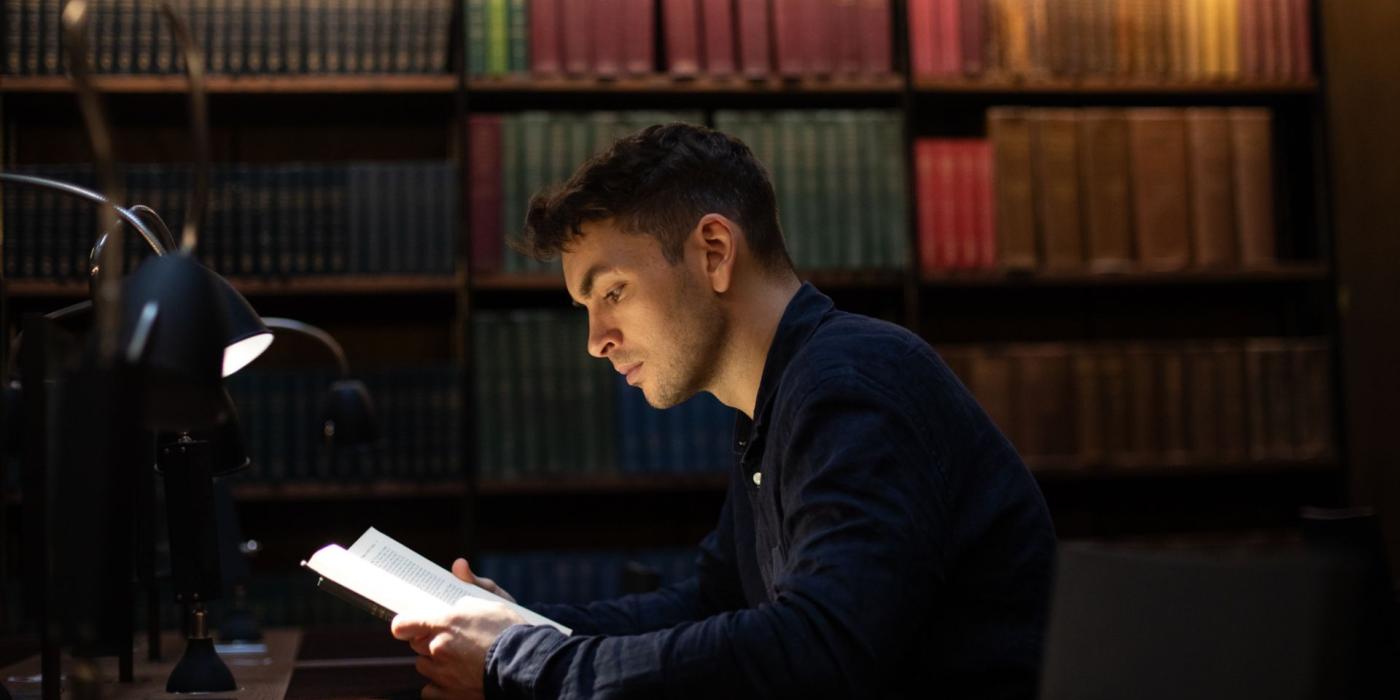 Man reading a book in the library