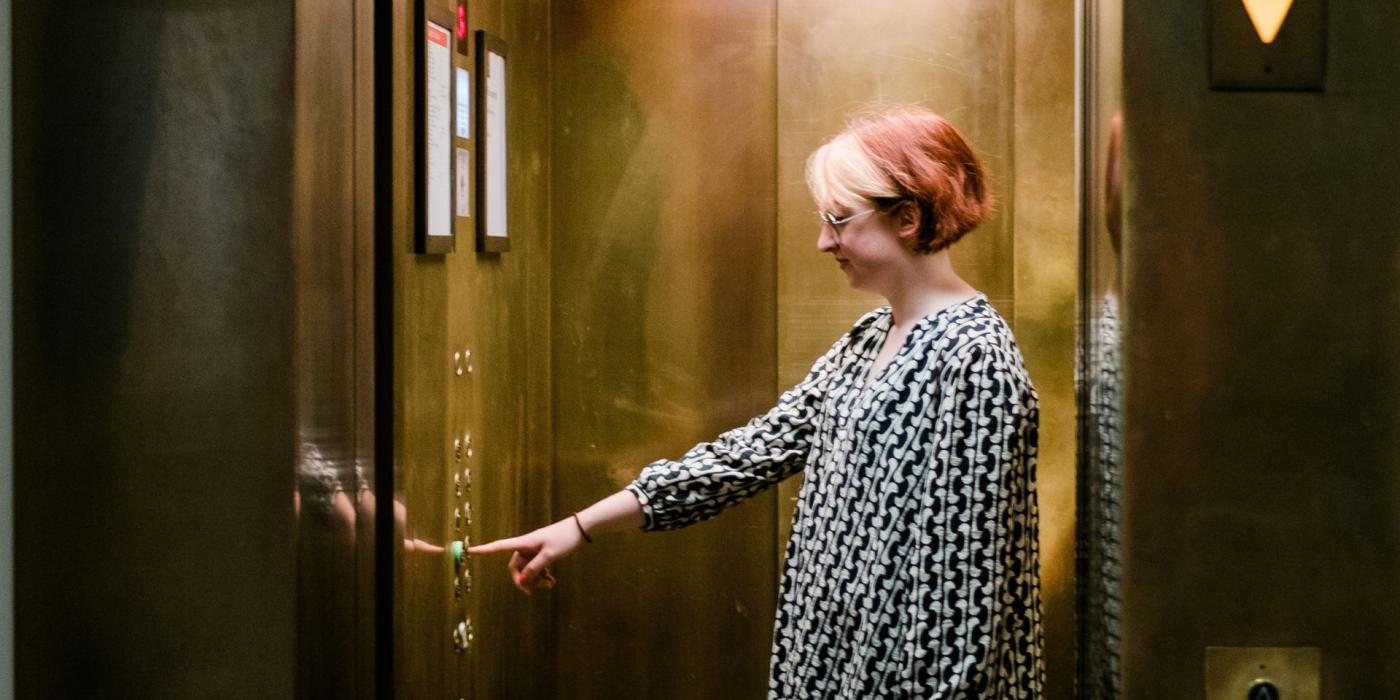 Lady in a lift pushing the button